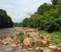 A disposal site in western Pennsylvania. showing a stream, a forest and two people